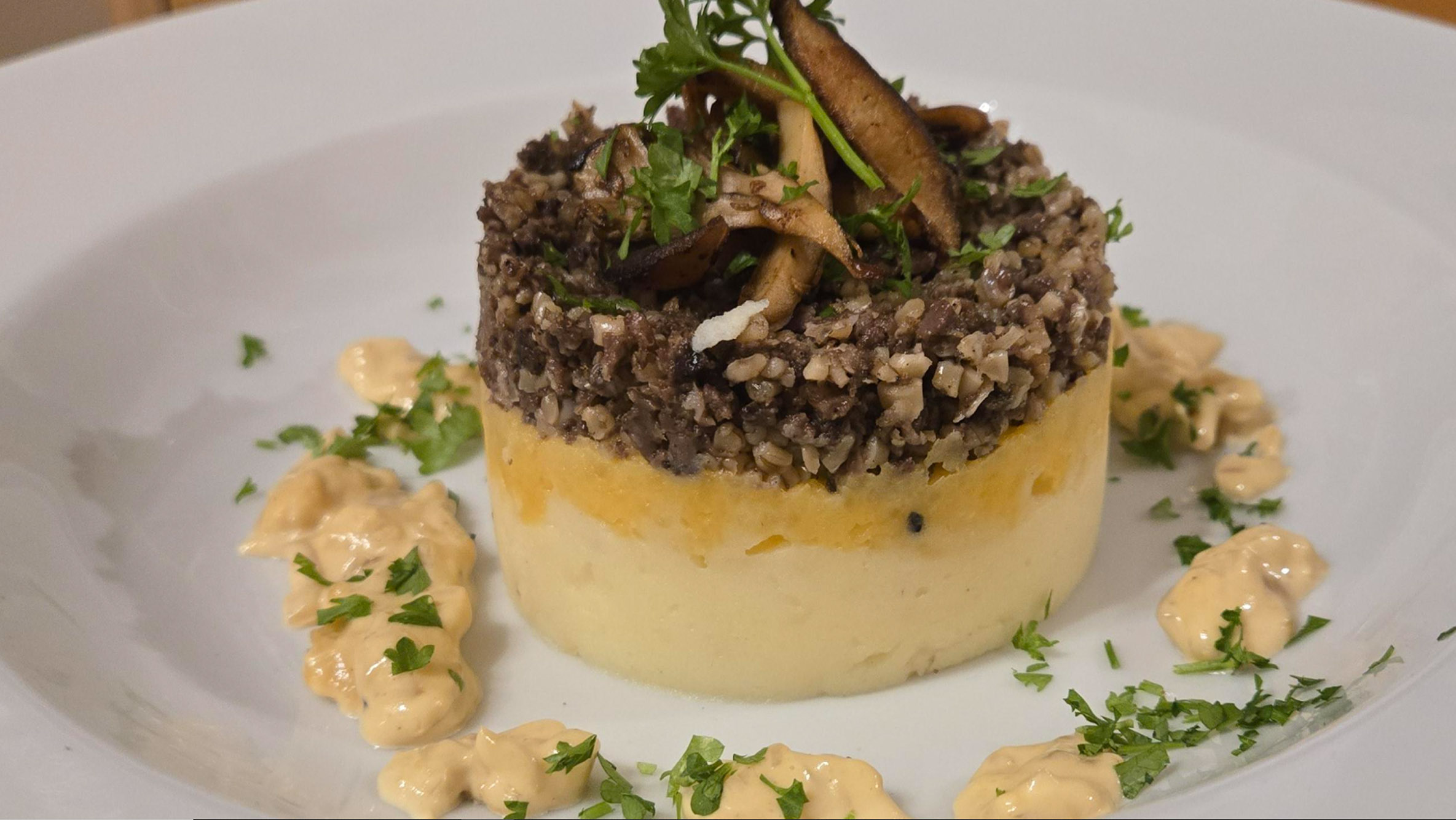 Haggis stacked with neeps and tatties, finished with a cream sauce and pea shoots.